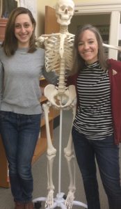 Learning Specialists Jackie and Robin standing on either side of a life-size skeleton replica.